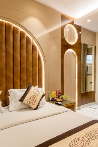 a bedroom with a large bed with a large headboard at Hotel Vanson Villa, City Centre - With Free Airport & Train Station Pickup in New Delhi