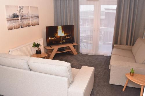 a living room with a white couch and a tv at Barnsley Town Centre Apartment in Barnsley