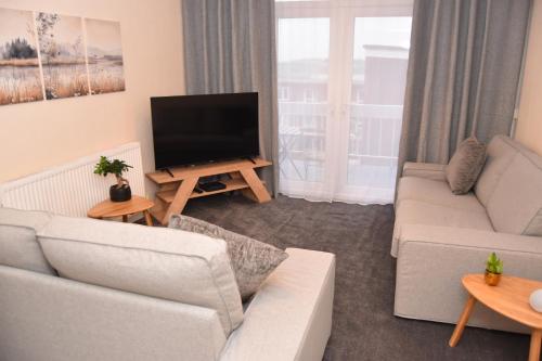 a living room with a couch and a flat screen tv at Barnsley Town Centre Apartment in Barnsley