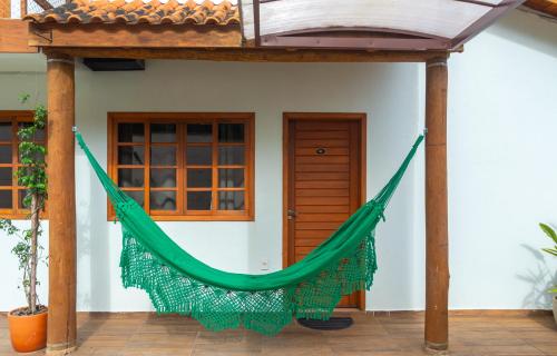 a hammock hanging outside of a house at Chalé com Churrasqueira a 5min da Praia Estaleiro in Balneário Camboriú