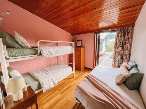 a bedroom with two bunk beds and a window at Camarinhas House in Moledo
