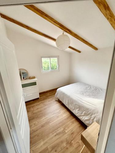 a small bedroom with a bed and a window at Nana Bloo in La Teste-de-Buch