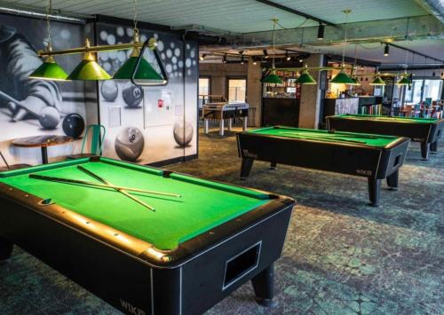 a room with two pool tables and ping pong balls at Aquapark Bel Mare F429 in Międzyzdroje