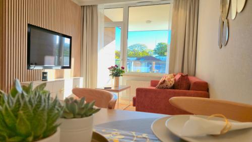 a living room with a red couch and a television at Aquapark Bel Mare F429 in Międzyzdroje