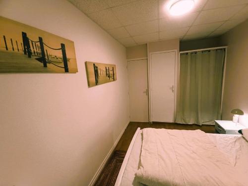a room with a bed and a painting on the wall at Échappée Belle au pied des Falaises in Le Tréport