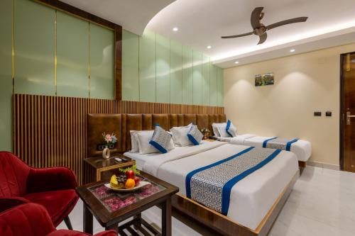 a hotel room with two beds and a chair at Hotel Vanson Villa, City Centre in New Delhi
