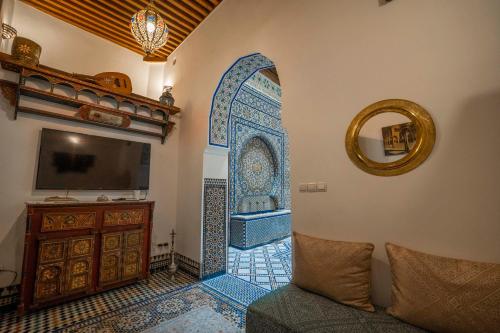 a living room with a mirror and a room with a tub at Dar Na in Station Bab Ftouh