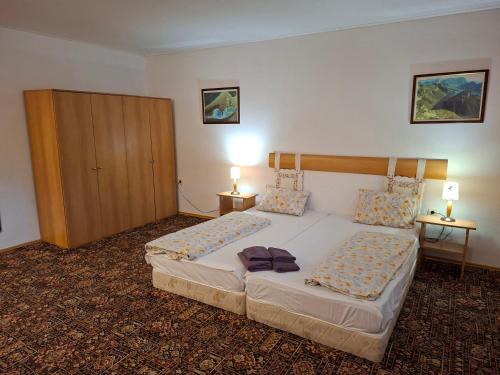 1 dormitorio con 2 camas, armario y 2 lámparas en Къща за гости У Нико, en Orehovo