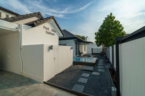 a side view of a house with a pool in a yard at 4BR Pool Villa Sukhum in Phuket Town in Changwat Phuket