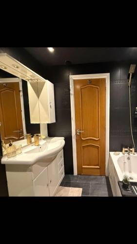 a bathroom with two sinks and a brown door at A Star Living in Liversedge