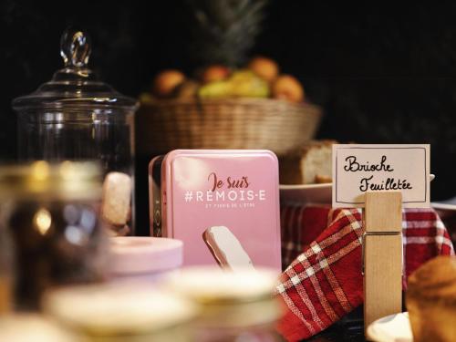 Mercure Reims Parc Des Expositions في رانس: طاولة عليها شمعة وردية اللون وسلة فواكه