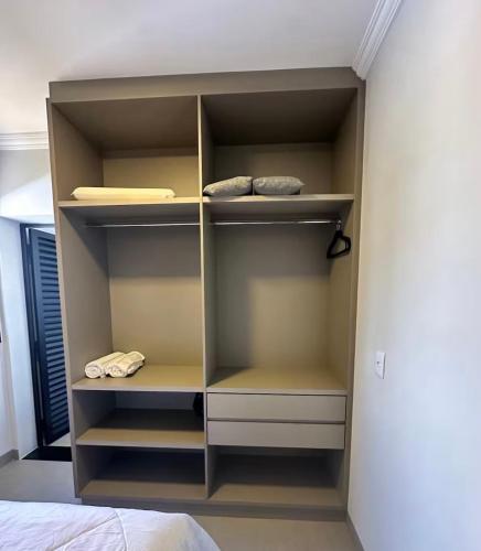 a closet with empty shelves in a bedroom at Studio Maia Aconchego e praticidade 190m da UFU in Uberlândia