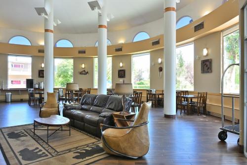 a lobby with a couch and tables and chairs at Puffin Inn in Anchorage