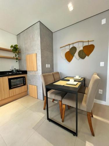 a dining room with a table and chairs in a kitchen at Apto Home & Club em Capão da Canoa in Capão da Canoa