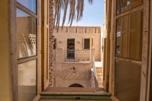 una vista de un edificio desde una ventana abierta en Dar Aron - Tozeur, en Tozeur