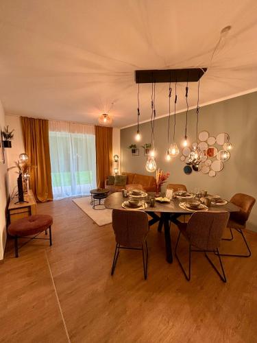 a dining room with a table and chairs and a living room at Stilvolles Apartment 3 Zi Klinik & Kurpark Terrasse Parkplatz Barrierefrei in Bad Oeynhausen