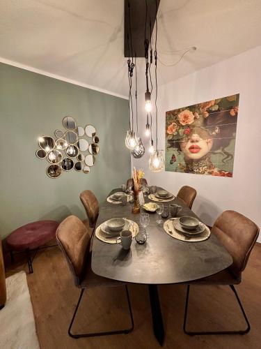 a dining room with a table with chairs and a painting at Stilvolles Apartment 3 Zi Klinik & Kurpark Terrasse Parkplatz Barrierefrei in Bad Oeynhausen