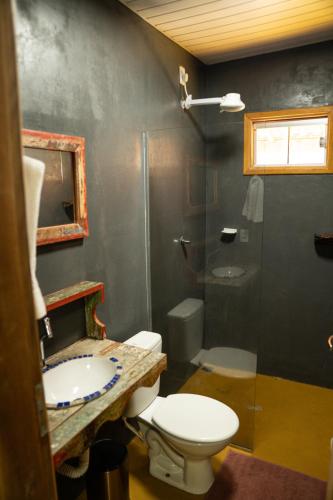 a bathroom with a toilet and a sink and a shower at Pousada Aracuã in Bonito