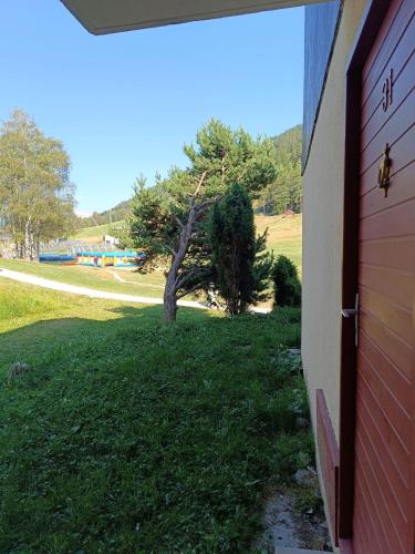 a door of a building next to a grass field at Les Arolles in Villarodin-Bourget