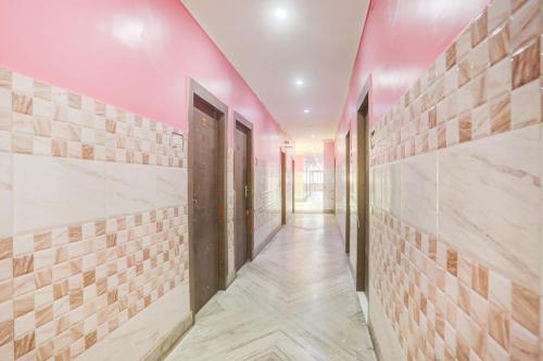 a corridor with a pink ceiling and a door at Hotel O Paras in Āsansol