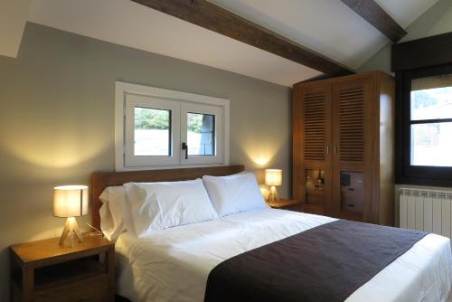 a bedroom with a large bed with two lamps at El Molino de Pochas in Bielsa