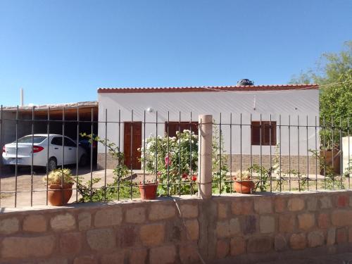 a fence in front of a building with potted plants at Alojamiento Don Carmelo in Fiambala