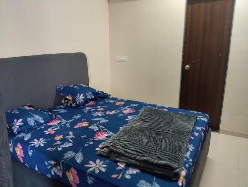 KolshetにあるDivine Homesのベッド(花の上に青い毛布付)