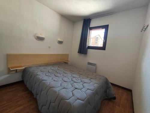 a bedroom with a bed and a window at Les Balcons de la Vanoise in La Norma