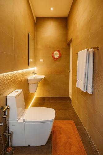 a bathroom with a white toilet and a sink at Spacious Eco Guest House Colombo in Sri Jayewardenepura Kotte