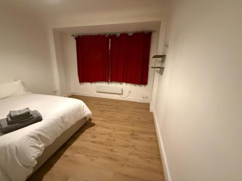 a bedroom with a bed and a red window at Spacious Stay in the Heart of the Town in Moffat