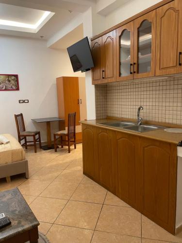 a kitchen with a sink and a living room at Guesthouse Joal in Përmet
