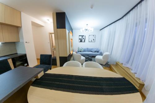 a living room with a table and white chairs at lux Apartman lazar in Pančevo