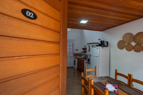 a kitchen with a table and a refrigerator at Praia do Estaleiro-BC, 2 vagas, Ar, Churras e Pet Friendly in Balneário Camboriú
