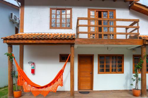 a house with an orange hammock in front of it at Praia do Estaleiro-BC, 2 vagas, Ar, Churras e Pet Friendly in Balneário Camboriú
