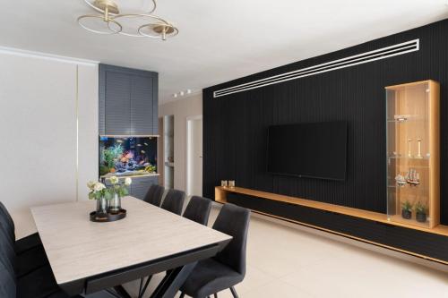 d'une salle à manger avec une table et une télévision à écran plat. dans l'établissement שקיעה חלומית בנתניה, à Netanya