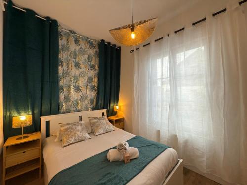 Saint-Aubin-lès-ElbeufにあるAppartement tout confort d Elbeuf -proche gareのぬいぐるみが置かれたベッドのある寝室