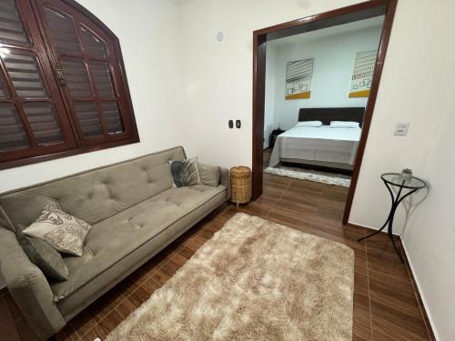 a living room with a couch and a mirror at Casa Sol & Lua in Espirito Santo Do Pinhal