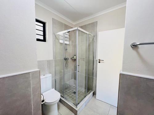 a bathroom with a glass shower with a toilet at Right at home in Boksburg