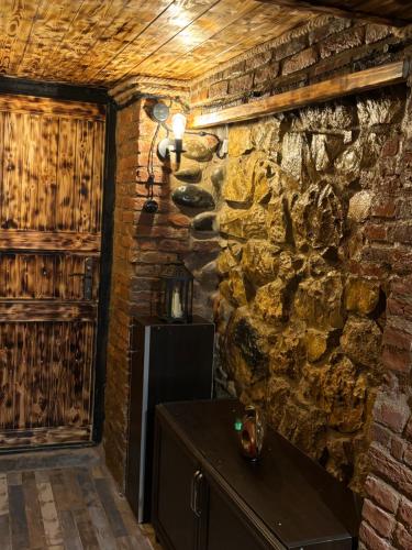 a room with a stone wall and a wooden door at Cozy Spot in Kutaisi