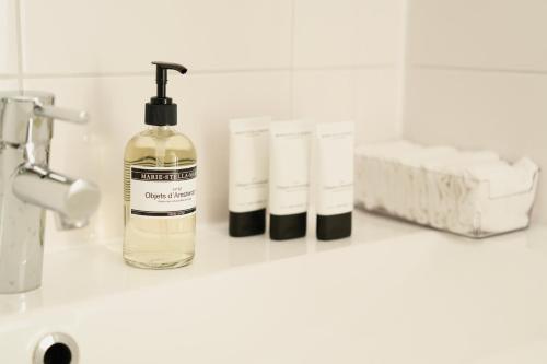 een badkamerbar met een fles zeep en toiletartikelen bij Chalet met hottub in Putten