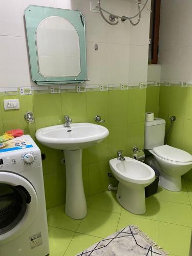 a bathroom with a sink and a toilet and a mirror at One Bedroom Apartment Lake View Pogradec in Pogradec