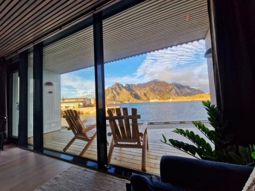 two chairs on a deck with a view of the water at Seafront apartment Henningsvær in Henningsvær