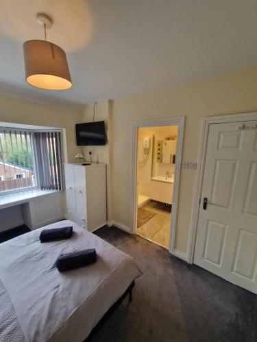 a bedroom with a bed with two black objects on it at Sheldon Apartments BHX HS2 JLR NEC in Birmingham