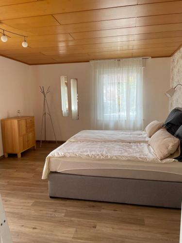 une chambre avec un grand lit avec un plafond en bois dans l'établissement Ferienwohnung im Hexental - Familienurlaub bei Freiburg & Schwarzwald, à Wittnau