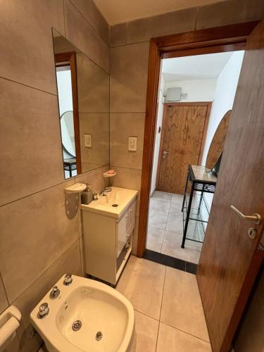 a bathroom with a toilet and a sink and a mirror at Loft Moderno - Natural - Rio in Rosario