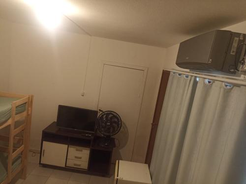 a small room with a television and a curtain at Bella house in Balneário Camboriú