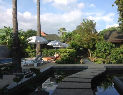 a pool at a resort with umbrellas at Rawai Boutique Resort in Rawai Beach