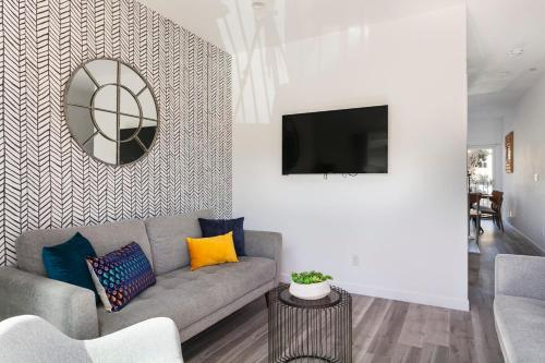 a living room with a couch and a mirror at Enjoy Stylish 4BR Townhouse Sleeps 8 with Wi-Fi in Los Angeles