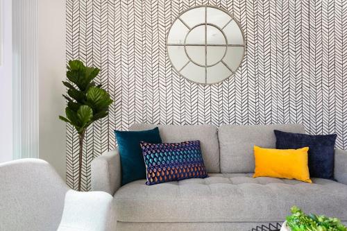 a living room with a gray couch with colorful pillows at Enjoy Stylish 4BR Townhouse Sleeps 8 with Wi-Fi in Los Angeles