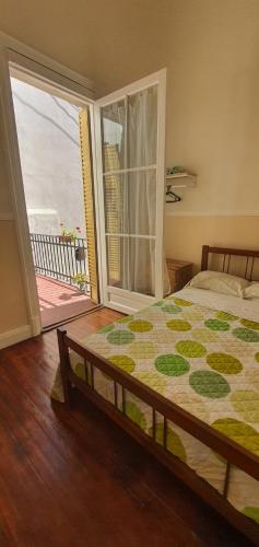 a bedroom with a bed and a sliding glass door at Hotel Cuba in Buenos Aires
